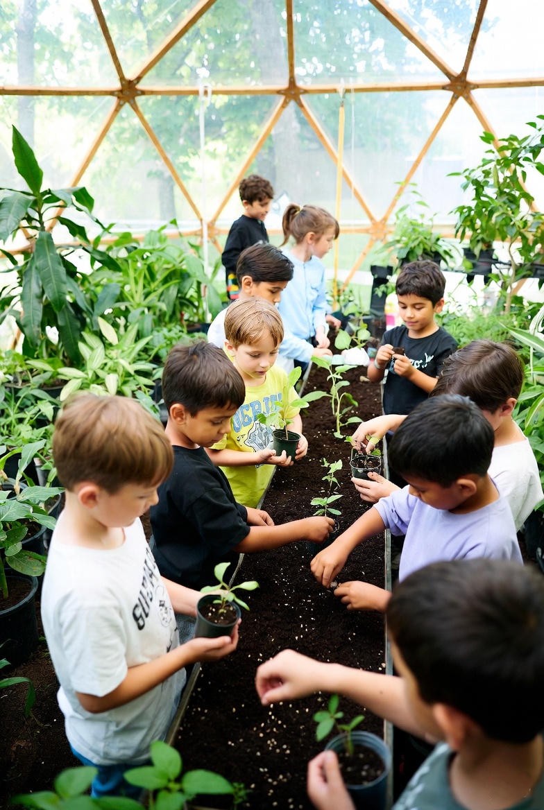 Children planting seeds inside the dome classroom